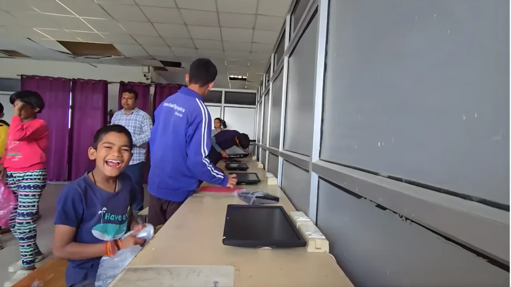 A happy child setting up an Apna PC at a digital learning center, showcasing the excitement of hands-on learning.