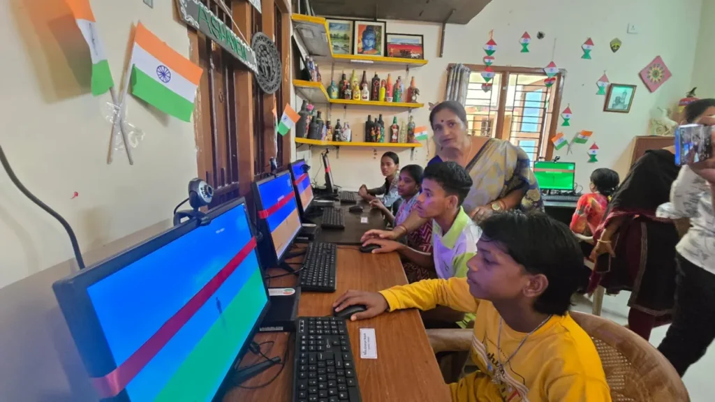 Apni Pathshala POD teaching Computers with Indian Flags near computers, showing How Can We Strengthen Indian Democracy?